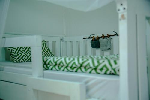 阿鲁沙Hakuna Woga Inn的白色长凳、绿色枕头和镜子