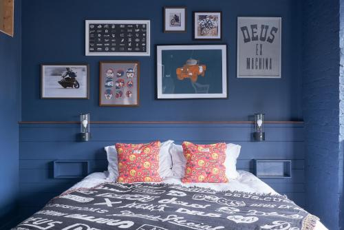 伯恩茅斯Deus Lodge of Heavy Leisure的一间卧室拥有蓝色的墙壁,配有一张带枕头的床。