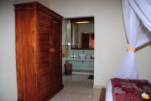 佩母德兰巴厘岛佩母德兰皇冠住宿加早餐旅馆的一间带大型木门和水槽的浴室