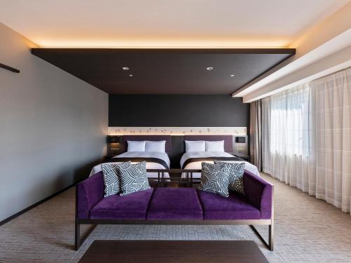 东京三井花园饭店京桥 / 东京站的卧室在床前配有紫色沙发