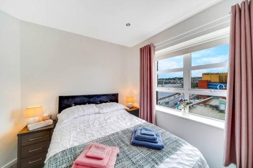 伦敦德里The Peace Bridge Apartment的一间卧室设有一张床和一个大窗户