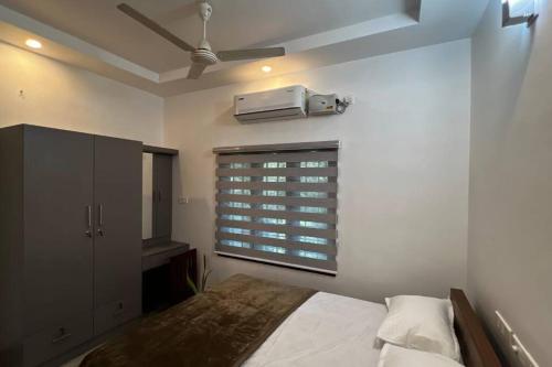 科钦Hosted by Resmi Jayalal的一间卧室配有一张床,窗户配有空调