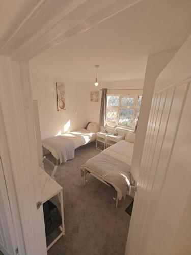 南安普敦Stunning 4 bed House Ideal for Contractors的一间卧室设有两张床和窗户。
