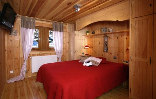 莱德萨阿尔卑斯Odalys Chalet Leslie Alpen 2的一间卧室,配有红色的床,上面有狗