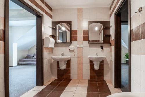 Głogów Małopolski兹特伯里鲁库酒店的浴室设有2个水槽和镜子
