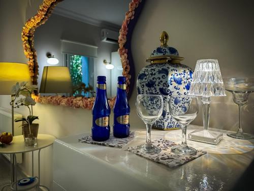 王子岛群hi HOTEL IVY BÜYÜKADA的一张桌子,上面放有瓶子和眼镜,花瓶
