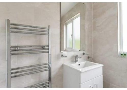 米查姆Chic 4BR Home in Mitcham Ideal for Families的白色的浴室设有水槽和窗户。