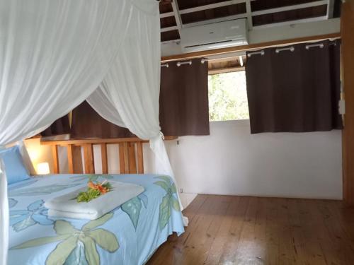 HaapuManta Lodge avec 4x4 Pleine nature的一间卧室配有一张白色天蓬床