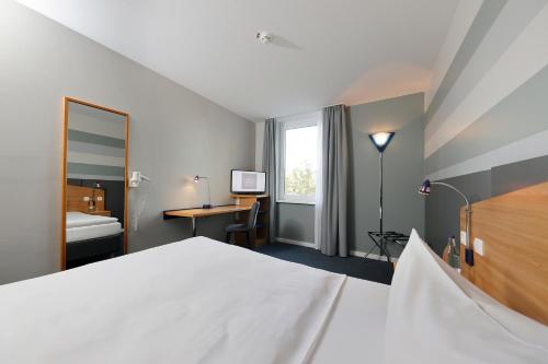 汉诺威汉诺威梅斯梅迪亚酒店的一间卧室配有一张床、一张书桌和一个窗户。