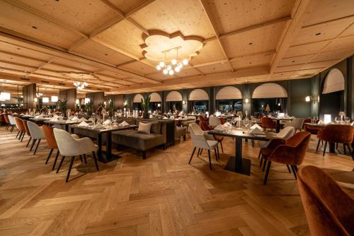 阿罗萨Waldhotel Arosa的一间带桌椅和吊灯的用餐室