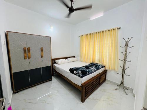 ThanniyamFurnished 2 BHK Family Apartments near Triprayar Shree Rama Temple - Beevees Homes Thriprayar的一间卧室设有一张床和一个窗口