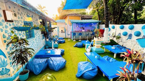 阿姆波尔Omkar wellness inn的一个带蓝色桌子和大屏幕的庭院