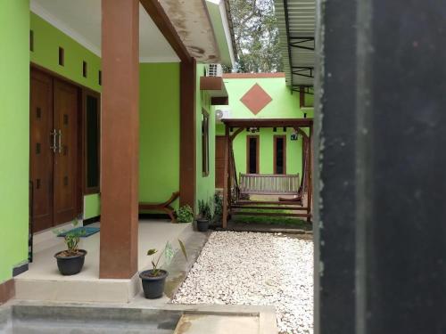KalasanMamora Guest House的享有带绿色墙壁的房子的景色