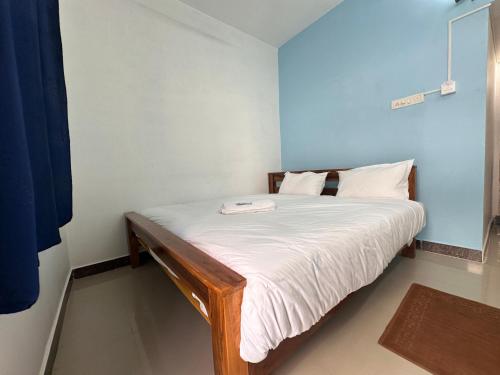 蒂鲁瓦纳马莱MPS Saai Residency的一间小卧室,配有白色床单