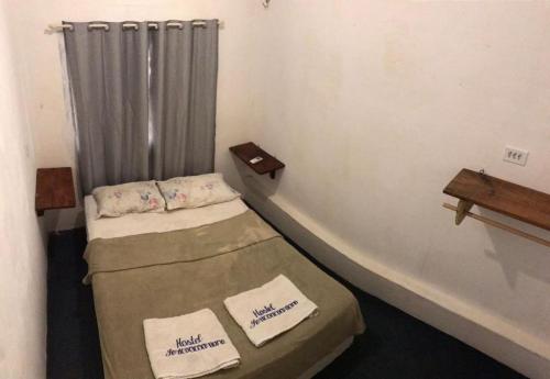 杰里科科拉Hostel Jericoacoariano的小房间设有两张床和窗帘