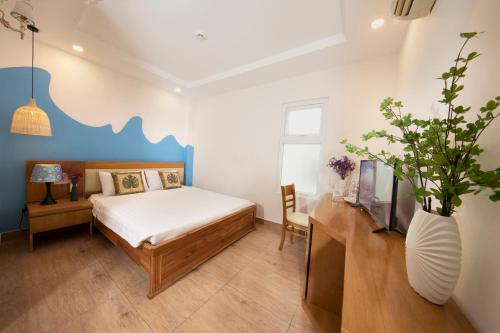 头顿Summer Beach Hotel Vung Tau的一间卧室,配有一张床和一个花瓶