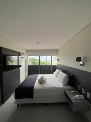 若昂佩索阿Flat ARPOAR Suítes Manaíra com vista para o mar的一间卧室设有一张大床和一个窗户。