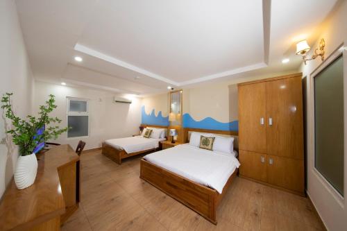 头顿Summer Beach Hotel Vung Tau的小房间设有两张床和电视