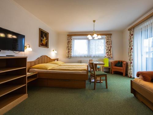 滨湖采尔Gästehaus Bleiweis-Zehentner的卧室配有1张床、1张桌子和1把椅子
