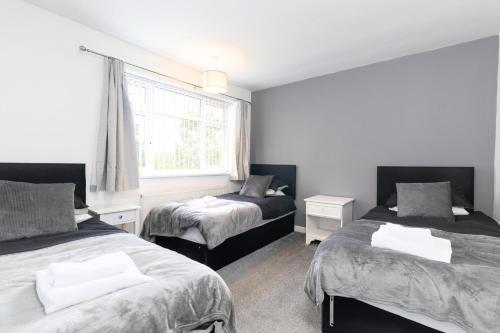 Coundon3 Bedroom Home with Private Driveway的一间卧室设有两张床和窗户。