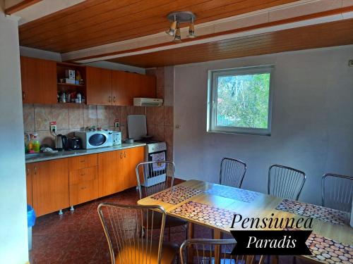 布什泰尼Pensiunea Paradis的一间厨房,里面配有桌椅