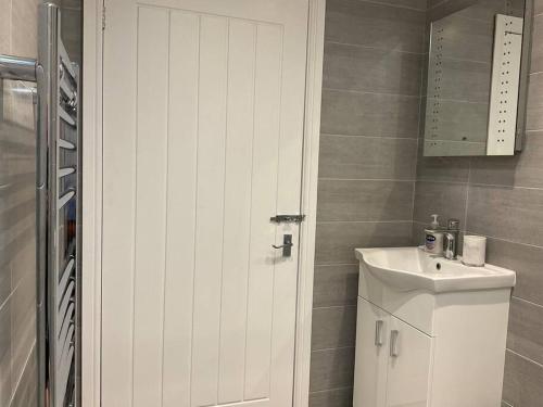 阿什伯恩Beautiful Cottage in Ashbourne的浴室配有白色橱柜和盥洗盆