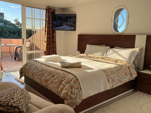 丰沙尔Villa Formosa的一间带大床的卧室和一个阳台