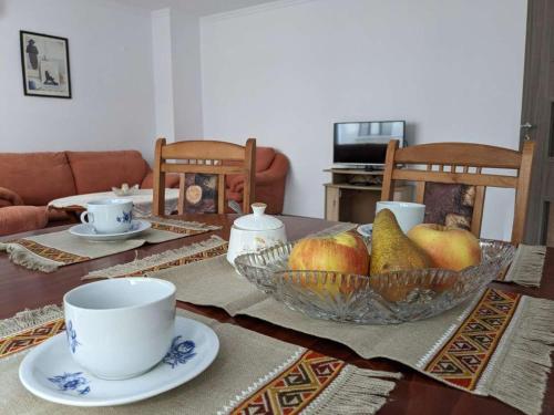 布尔加斯Lazur Apartment的餐桌,放上一碗水果和一杯
