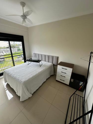 弗洛里亚诺波利斯Hostel APÊ DO CRIS的一间卧室配有一张床、一个梳妆台和一扇窗户。