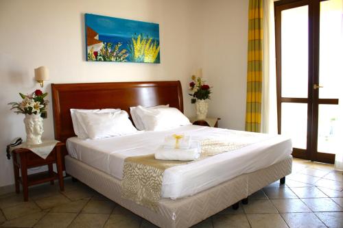 马里内拉Grand Hotel Selinunte的一间卧室配有一张大床和木制床头板