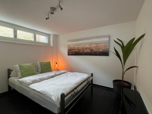 ObergösgenThe R Apartment Froburg, Parking, Netflix, Golfplatz的一间卧室配有一张床和盆栽植物