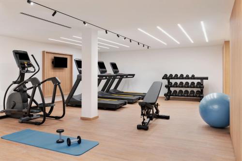 比尔Courtyard by Marriott Biel Bienne的健身房设有跑步机椭圆机和蓝色运动球