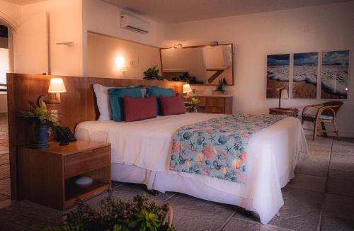 卡莫辛Sun City Rota das Emoções的酒店客房设有一张大床和一张桌子。