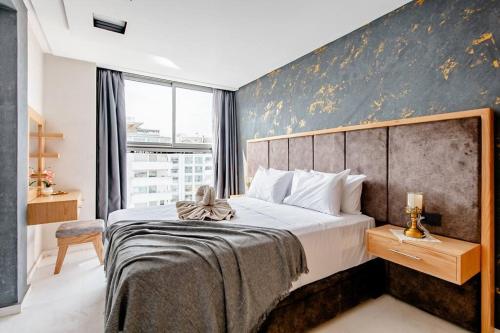丹吉尔Élégant appart tanger boulevard的一间卧室设有一张大床和一个大窗户