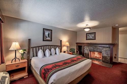杰克逊安特勒酒店的一间卧室设有一张大床和一个壁炉