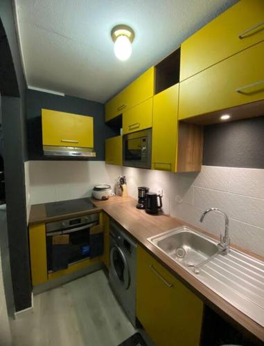卡宴Quiet Place的厨房配有黄色橱柜和水槽