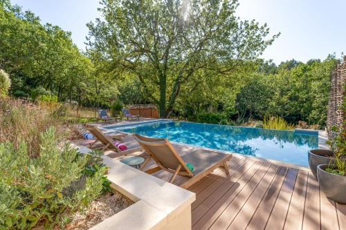 赛尼翁Villa Vauvert的后院设有游泳池和木甲板