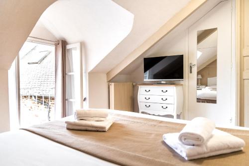 迪南Demeures & Châteaux - Hôtel De La Porte Saint-Malo的白色卧室,配有带毛巾的床