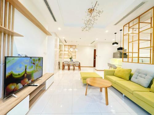 胡志明市Luxury Vinhomes Central Park (Cozy Apartment)的客厅配有黄色沙发和平面电视。