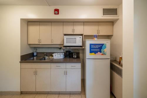 温哥华瓦尼埃学生宿舍帕西斯比特旅馆的小厨房配有冰箱和微波炉。