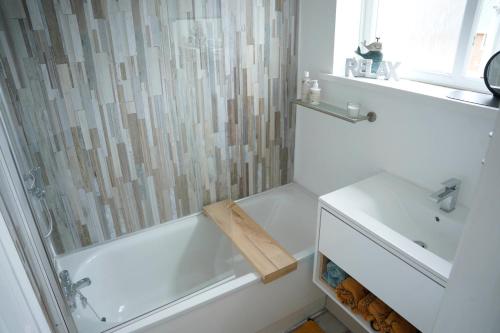 锡厄姆Sara’s Apartment的带淋浴和盥洗盆的白色浴室