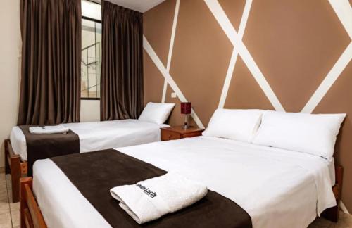 皮乌拉Hotel Santa Lucia - Oficial的酒店客房,配有两张带白色床单的床