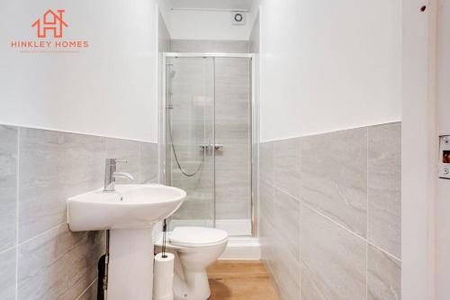 利物浦Supersized 6 bedroom Liverpool/Free parking/sleeps 12的白色的浴室设有水槽和卫生间。