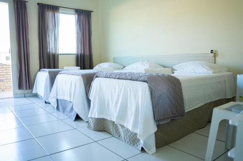 巴纳伊巴Pousada Aeroporto的酒店客房的三张床