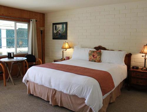 圣路易斯-奥比斯保Back Bay Inn的一间卧室配有一张大床和一张桌子
