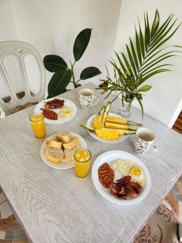 托舵道斯Le Dodo Appartements的餐桌,带早餐食品盘和咖啡杯