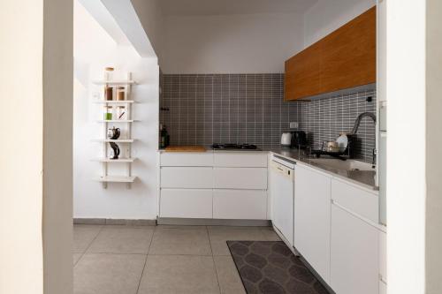 拉马特甘Family Apartment By IsrApart的厨房配有白色橱柜和水槽