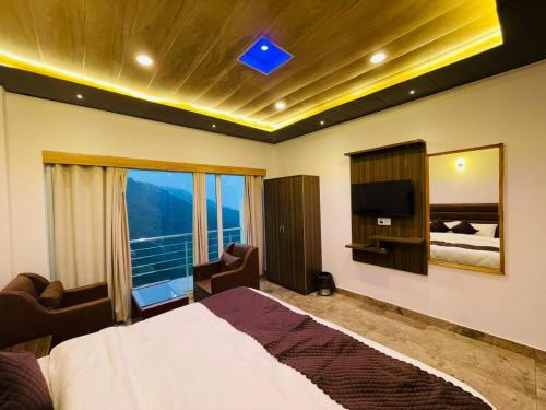 西姆拉Hotel candlewood Shimla的一间卧室设有一张床、一台电视和一个窗口。