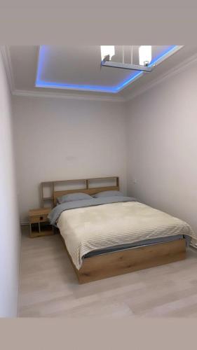 久姆里Lidiani Guest House的一间卧室设有一张床和一个蓝色的窗户。