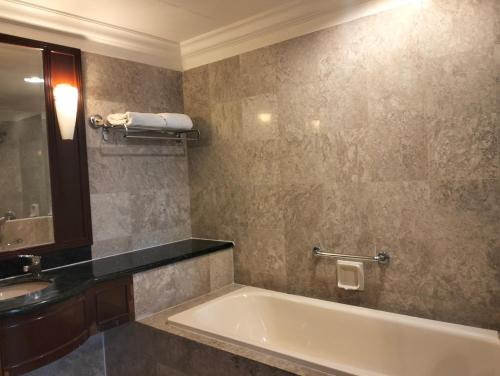 吉隆坡Times Square Service Suites Kuala Lumpur的带浴缸、水槽和镜子的浴室